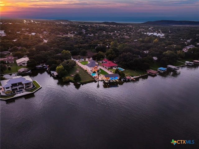 aerial view at dusk featuring a water view