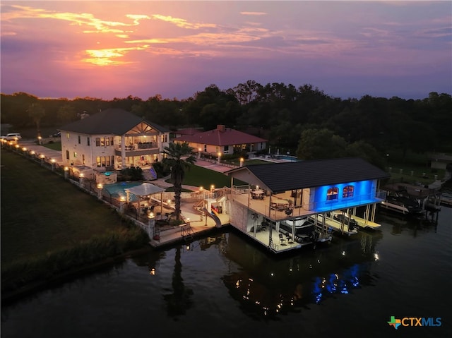 back house at dusk with a water view