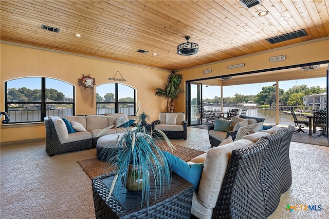 carpeted living room featuring wood ceiling and a water view