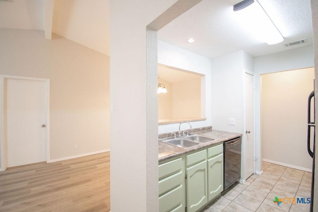 kitchen featuring visible vents, black dishwasher, light countertops, a sink, and green cabinets