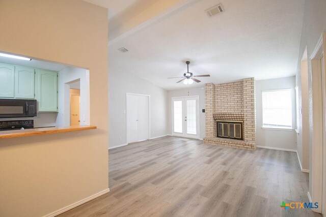 unfurnished living room featuring light wood-style floors, a ceiling fan, baseboards, and a fireplace