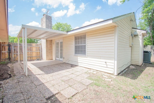 rear view of house featuring a patio, central air condition unit, a chimney, and fence