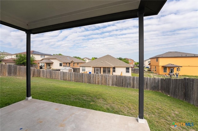 view of yard with a fenced backyard, a residential view, and a patio