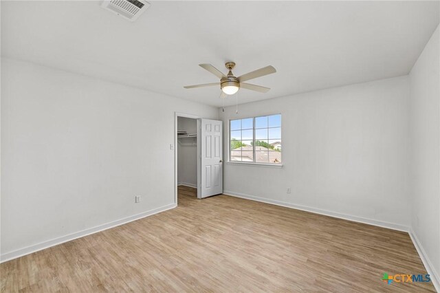 unfurnished bedroom with visible vents, a closet, baseboards, light wood-style flooring, and ceiling fan