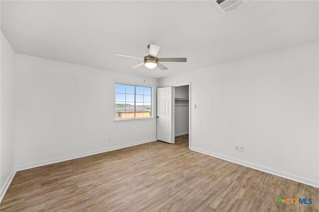 unfurnished bedroom with wood finished floors, visible vents, baseboards, and ceiling fan