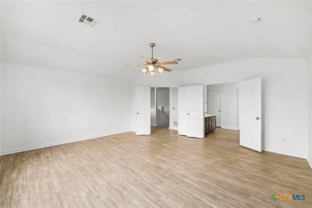 unfurnished bedroom featuring vaulted ceiling, ceiling fan, light wood finished floors, baseboards, and visible vents