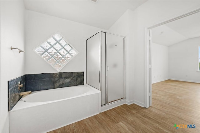 full bathroom with lofted ceiling, wood finished floors, baseboards, a garden tub, and a stall shower