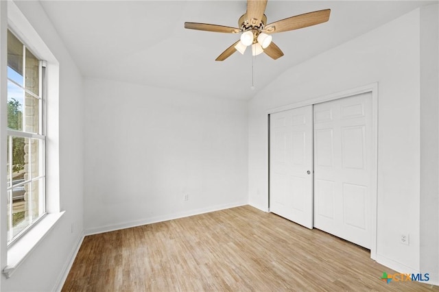 unfurnished bedroom featuring baseboards, multiple windows, and light wood-style flooring