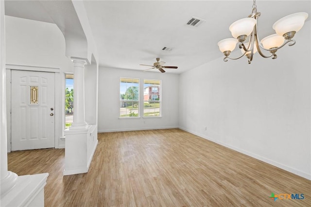 foyer entrance featuring light wood finished floors, decorative columns, baseboards, visible vents, and ceiling fan with notable chandelier