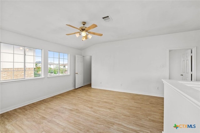 unfurnished room featuring baseboards, a ceiling fan, visible vents, and light wood-style flooring