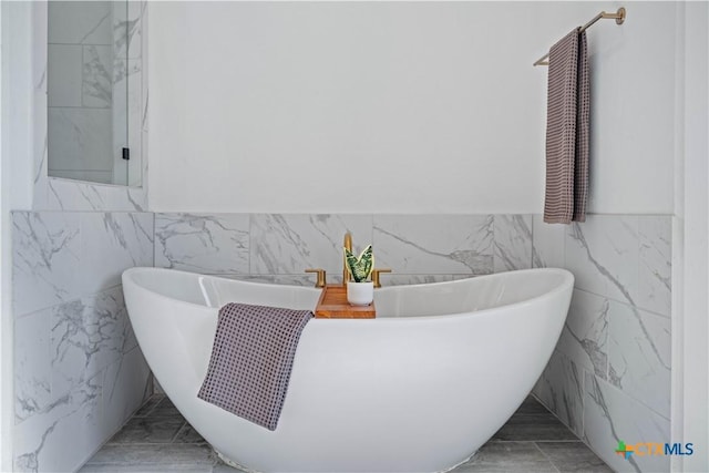385 Althea, New Braunfels, TX 78132 - bathroom with tile walls, a wainscoted wall, a soaking tub, and marble finish floors