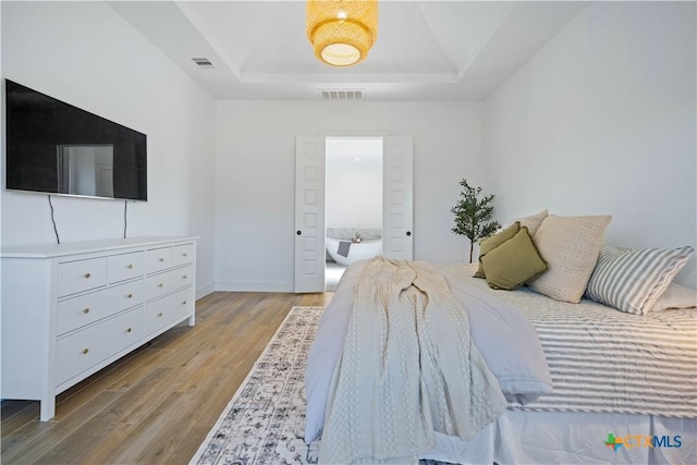 385 Althea, New Braunfels, TX 78132 - bedroom featuring a raised ceiling, light wood-style floors, and baseboards