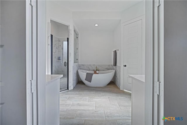 385 Althea, New Braunfels, TX 78132 - full bathroom with a marble finish shower, tile walls, a freestanding bath, vanity, and recessed lighting
