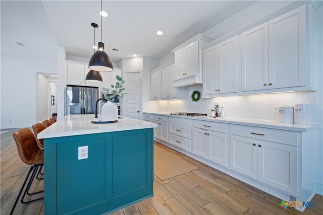 385 Althea, New Braunfels, TX 78132 - kitchen featuring stainless steel refrigerator with ice dispenser, light wood-style floors, tasteful backsplash, a kitchen breakfast bar, and recessed lighting