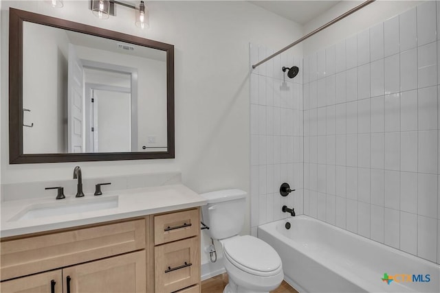 full bathroom featuring toilet, vanity, and tiled shower / bath