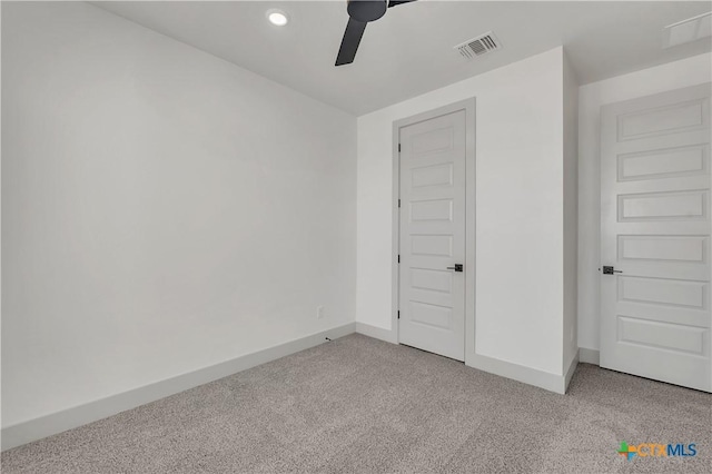 unfurnished bedroom featuring light colored carpet, a closet, and ceiling fan