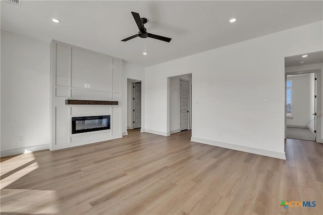 unfurnished living room featuring ceiling fan and light hardwood / wood-style flooring