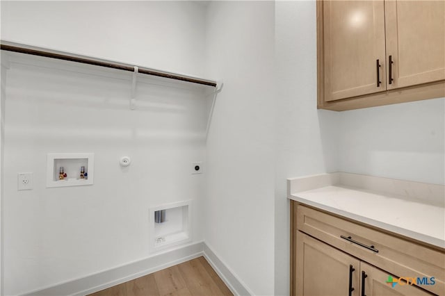 laundry area featuring electric dryer hookup, gas dryer hookup, cabinets, light hardwood / wood-style floors, and washer hookup