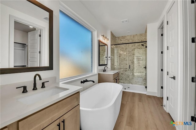 bathroom with wood-type flooring, vanity, and separate shower and tub