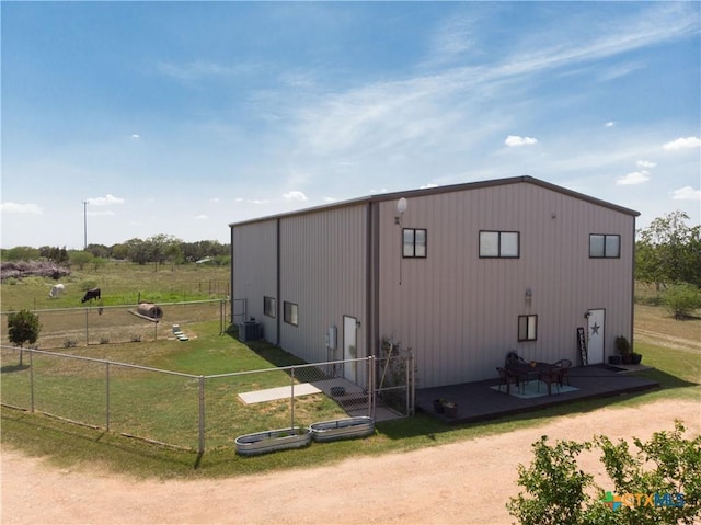 view of outbuilding featuring central AC unit and fence