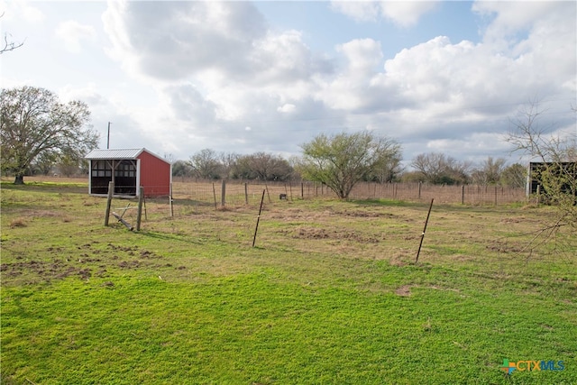 view of yard featuring an outbuilding, a pole building, and a rural view