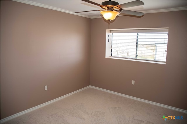 carpeted empty room with ceiling fan, baseboards, and crown molding