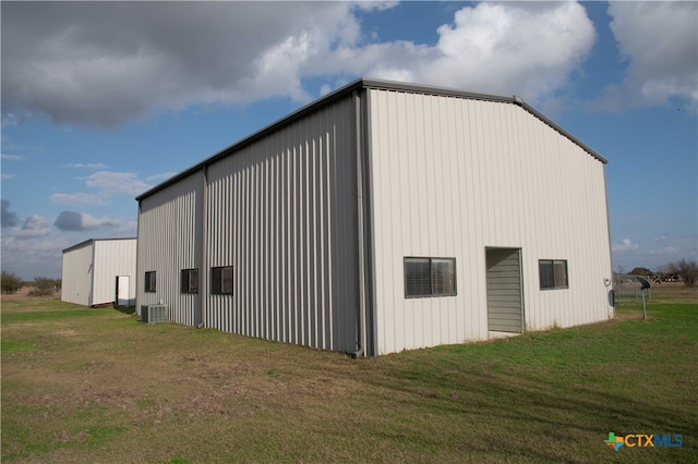 view of pole building with central AC unit and a lawn