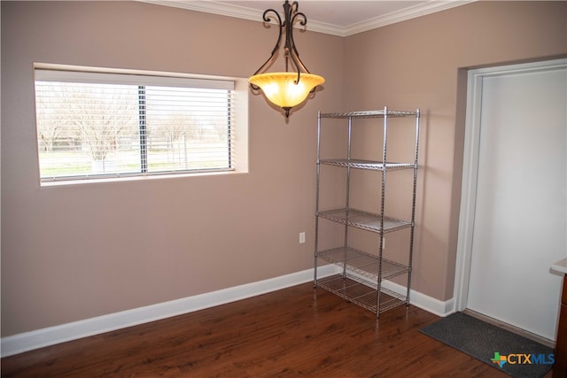 unfurnished dining area featuring dark wood-style floors, ornamental molding, and baseboards