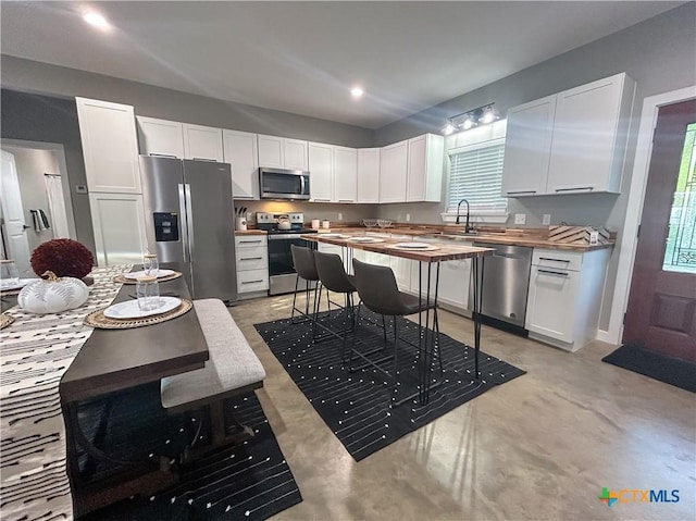 3306 Cypress, Victoria, TX 77901 - kitchen with stainless steel appliances, wooden counters, white cabinetry, healthy amount of natural light, and recessed lighting