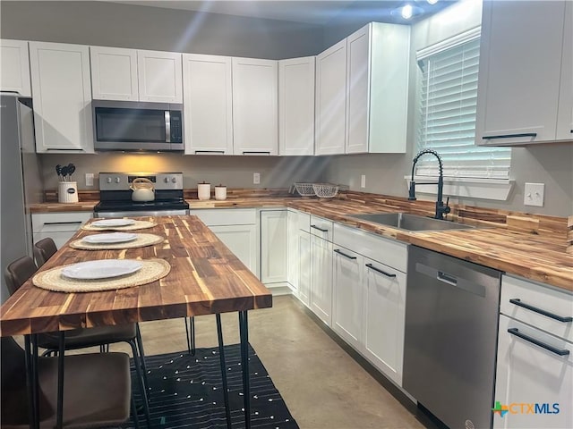3306 Cypress, Victoria, TX 77901 - kitchen with appliances with stainless steel finishes, wood counters, and white cabinets