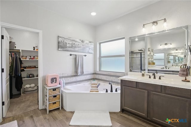 5106 La Piedra Ln, Killeen, TX 76549 - bathroom featuring vanity, a bath, wood finished floors, and a walk in closet