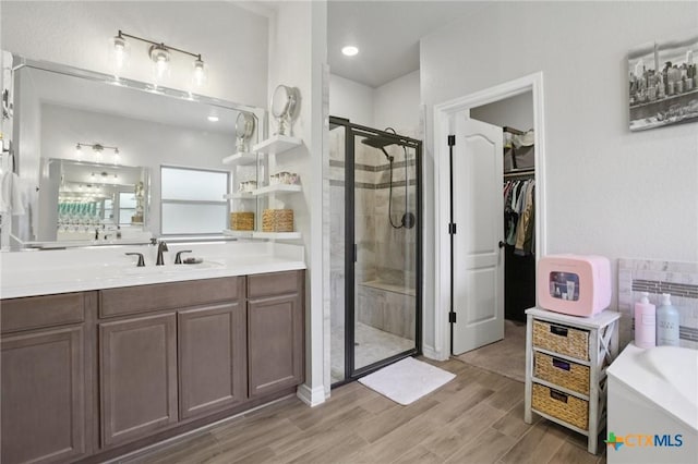 5106 La Piedra Ln, Killeen, TX 76549 - bathroom with a shower stall, a bath, vanity, wood finished floors, and a walk in closet