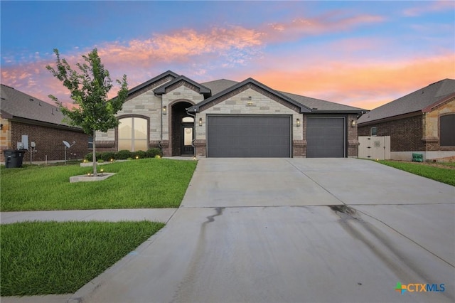 5106 La Piedra Ln, Killeen, TX 76549 - french country style house featuring an attached garage, concrete driveway, a front yard, and stone siding