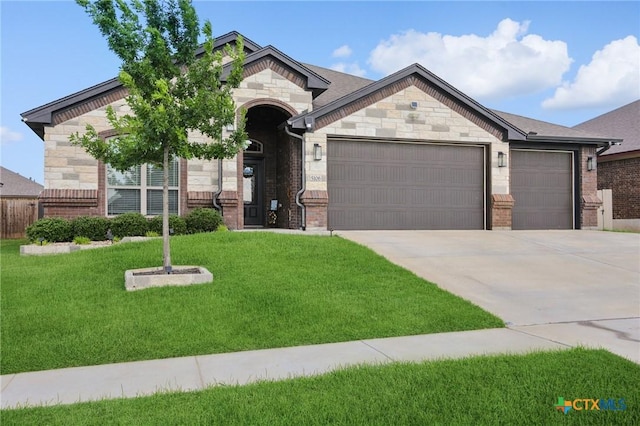 5106 La Piedra Ln, Killeen, TX 76549 - french country inspired facade featuring an attached garage, concrete driveway, a front yard, stone siding, and brick siding