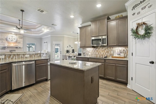 5106 La Piedra Ln, Killeen, TX 76549 - kitchen featuring stainless steel appliances, ornamental molding, backsplash, a ceiling fan, and a kitchen island