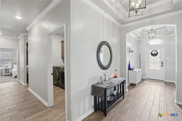 5106 La Piedra Ln, Killeen, TX 76549 - foyer featuring arched walkways, light wood finished floors, a chandelier, ornamental molding, and a raised ceiling