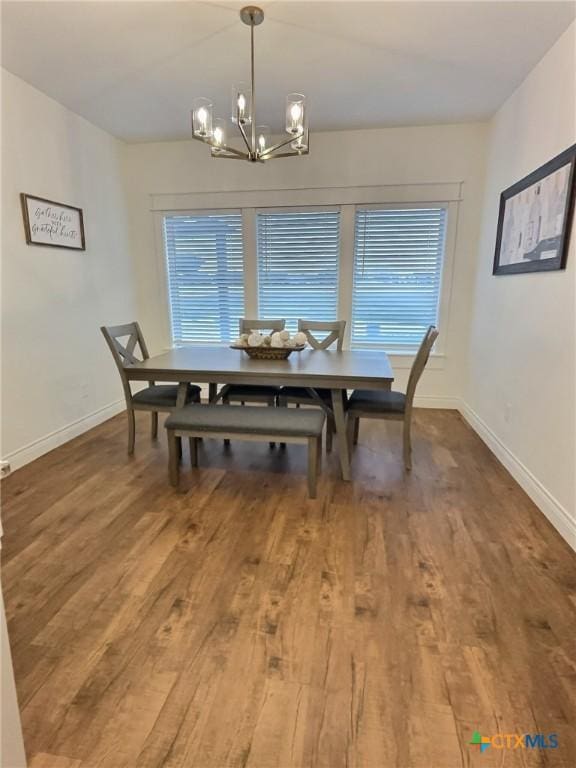 dining space with a healthy amount of sunlight, a chandelier, and wood-type flooring