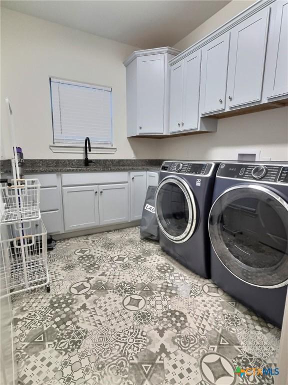 laundry room featuring washer and dryer, cabinets, light tile patterned floors, and sink