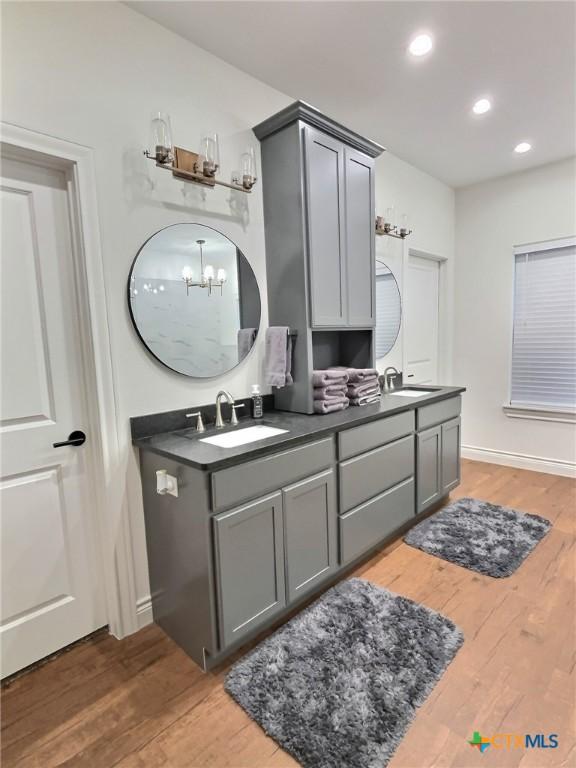 bathroom with a chandelier, wood-type flooring, and vanity