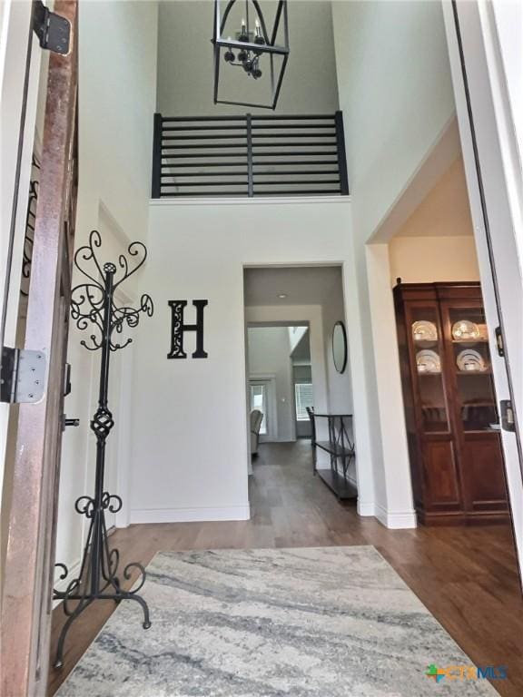 foyer with a high ceiling, hardwood / wood-style flooring, and a notable chandelier