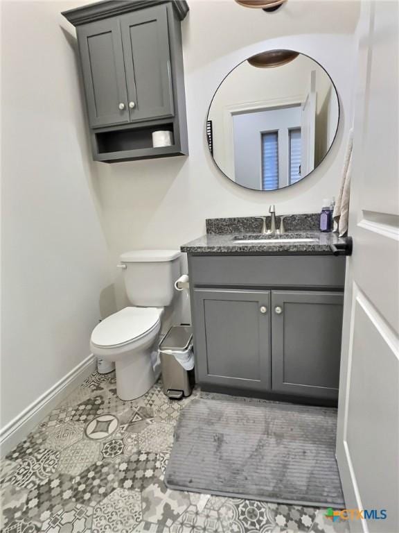 bathroom featuring tile patterned flooring, vanity, and toilet