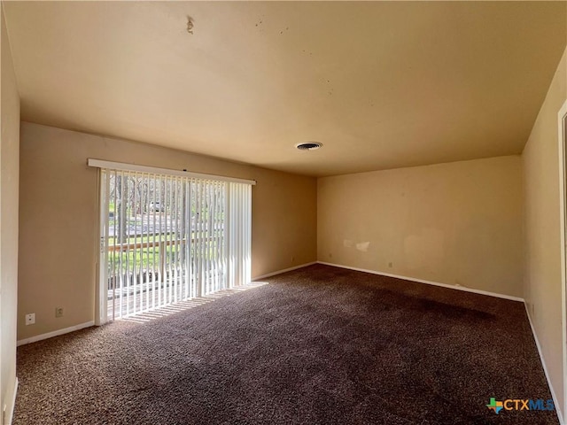 empty room featuring carpet flooring, visible vents, and baseboards