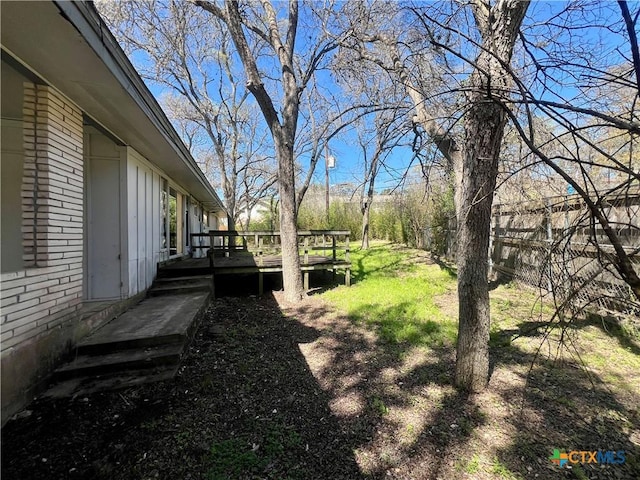 view of yard featuring a deck and fence