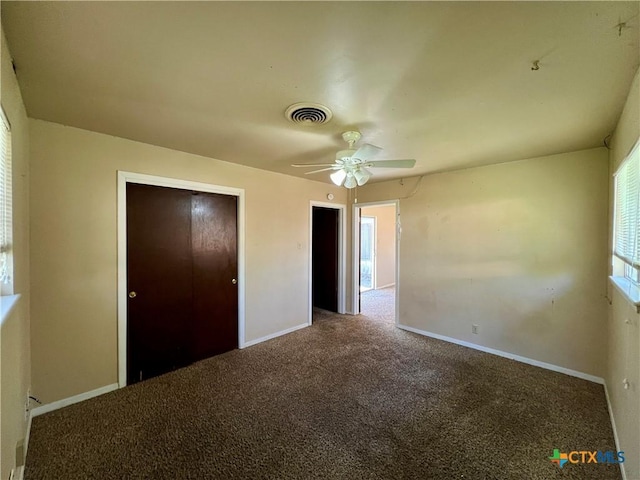 unfurnished bedroom with a ceiling fan, carpet flooring, baseboards, and visible vents