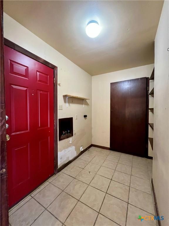 foyer featuring baseboards and light tile patterned flooring