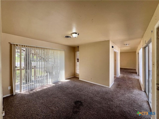 spare room featuring visible vents, carpet floors, and baseboards