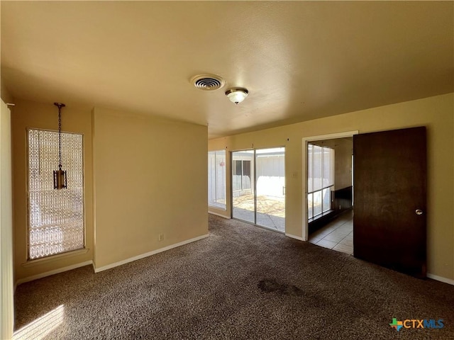 carpeted empty room with visible vents and baseboards