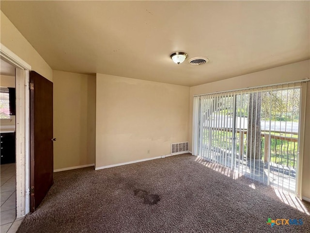 empty room with visible vents, baseboards, and carpet