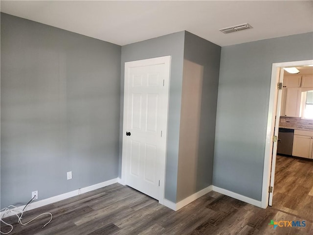325 Montgomery St, Yoakum, TX 77995 - unfurnished bedroom with dark wood-style flooring and baseboards