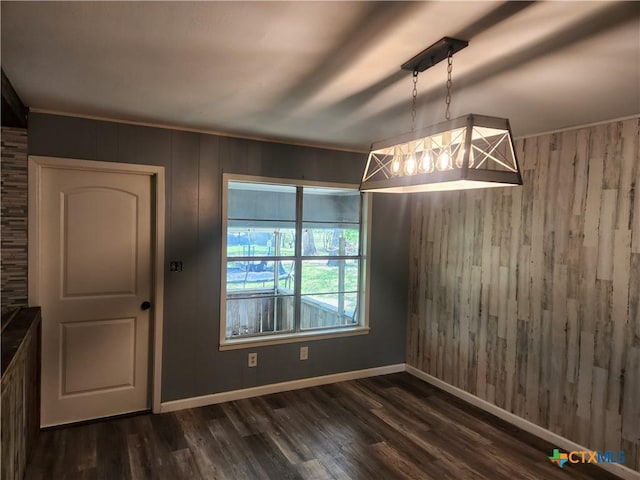 325 Montgomery St, Yoakum, TX 77995 - unfurnished dining area with wooden walls and dark wood-type flooring